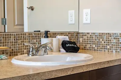 a bathroom counter with a sink and a mirror at The Venti - 3BD 2BA Yard Garage & Upper Suite in Calgary