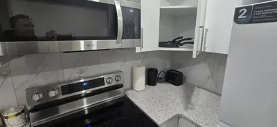 a kitchen with a microwave and a stove at Cozzy Cityscape & Airport Retreat in Calgary