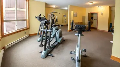 a gym with several tread machines in a room at Riverside Way by Fernie Lodging Company in Fernie
