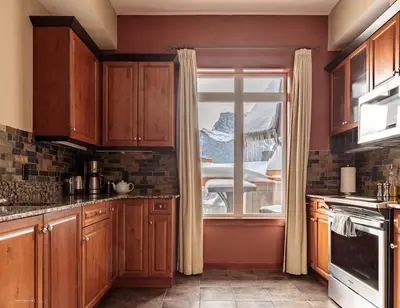 a kitchen with wooden cabinets and a window at Sun Drenched Escape - 50 Percent Off Apr - May in Canmore