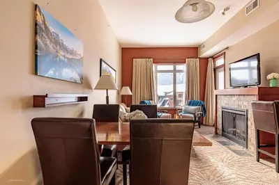 a living room with a table and a fireplace at Sun Drenched Escape - 50 Percent Off Apr - May in Canmore