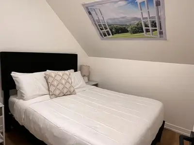 a bedroom with a white bed with a window at Top FL 2BR 2BA Hot Tubs phenomenal mountain views in Canmore