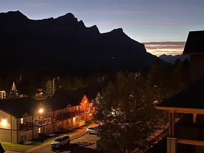 a town at night with a mountain in the background at Top FL 2BR 2BA Hot Tubs phenomenal mountain views in Canmore