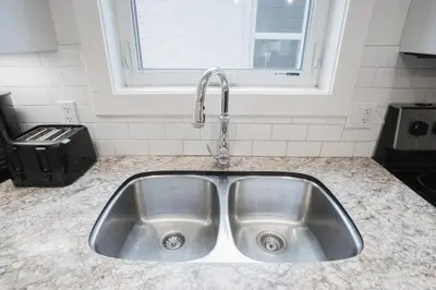 a stainless steel sink in a kitchen with a window at DOWNTOWN KINGBED 4Br FIREPLACE BIKELANE in Edmonton