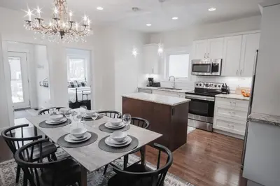 a kitchen with a dining room table with chairs and a chandelier at DOWNTOWN KINGBED 4Br FIREPLACE BIKELANE in Edmonton