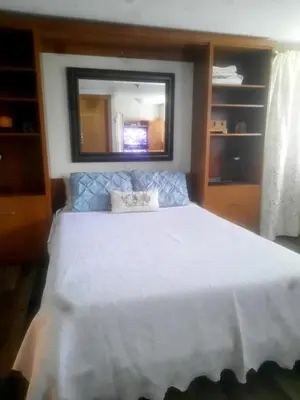 a bedroom with a large white bed with a window at Simply Suite - Sua Casa Longe de Casa in YYJ