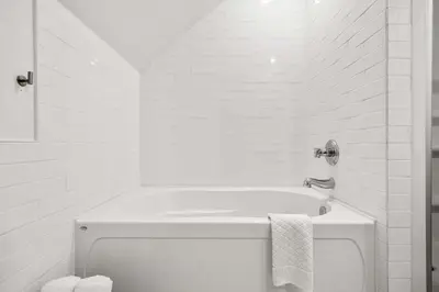 a white bathroom with a tub and a sink at Radiant Retreat -Spacious Home - Heart of Radium! in Radium Hot Springs