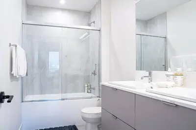a white bathroom with a toilet and a shower at Alpenstoke in Revelstoke
