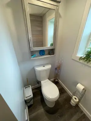 a small bathroom with a toilet and a mirror at Passage view in Campbell River