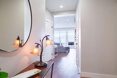 a living room with a table and a mirror at 2 Bedroom with Lake and Mtn Views in Harrison Hot Springs