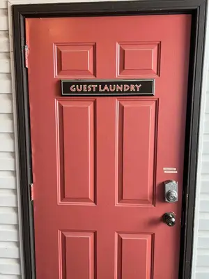 a red door with a guest laundry sign on it at Mountain Edge Resort Inn by StayIn in Kimberley
