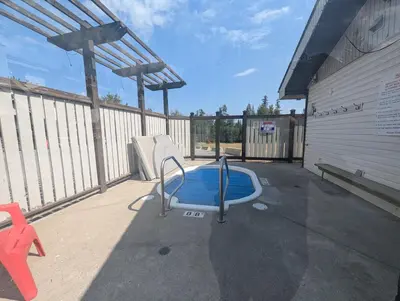 a swimming pool on a patio with a fence at Mountain Edge Resort Inn by StayIn in Kimberley