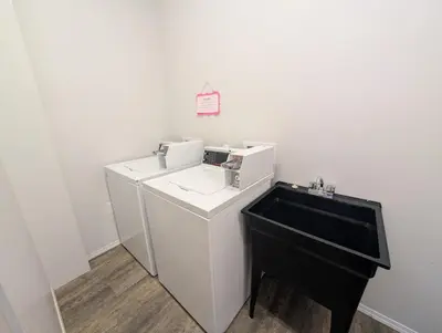 a white bathroom with a sink and a black counter at Purcell Condos by StayIn in Kimberley