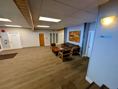 an empty room with a couch and chairs in an office at Purcell Condos by StayIn in Kimberley