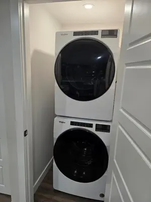 a microwave oven sitting on top of a washer and dryer at Cozy 2 Bedroom Walkout Basement in Calgary