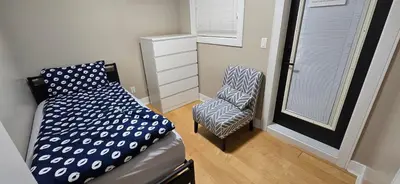 a small bedroom with a bed and a chair at Burnaby 4 bed 3 bath duplex in Burnaby
