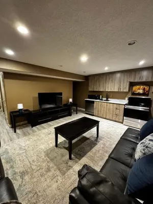 a living room with a couch and a piano at Cozy and Spacious Basement in Chestermere