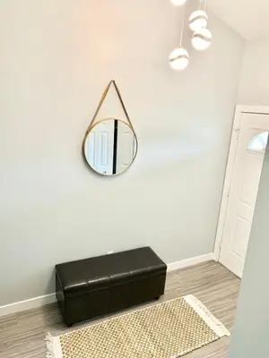 a room with a mirror and a black ottoman at Spacious Drumheller-RetreatMuseum & Golf in Drumheller