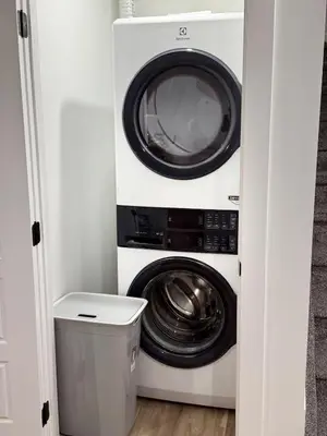 a washing machine and a washer and dryer in a closet at Charming Basement Suite in Edmonton