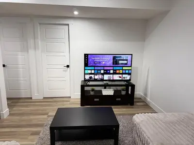 a living room with a flat screen tv on a wall at Charming Basement Suite in Edmonton