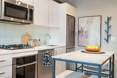 a kitchen with a table with a bowl of fruit on it at Stylish Condo with Exclusive Rooftop Pool in Calgary