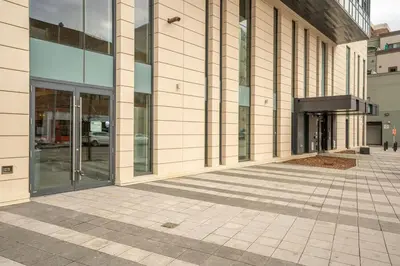 a building with glass doors on the side of it at Stylish Condo with Exclusive Rooftop Pool in Calgary