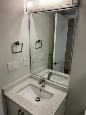 a bathroom with a sink and a large mirror at Spacious one Bedroom Suite Right in Downtown ! in Maple Ridge District Municipality