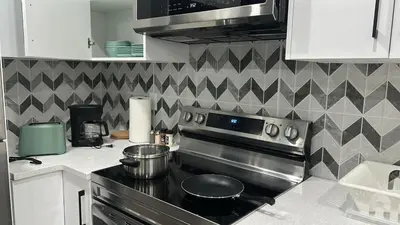 a kitchen with a stove with pots and pans on it at Haven Lodge, 2BR Brand New Basement Suite in Calgary