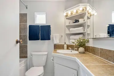 a white bathroom with a toilet and a sink at Bluebird 3 Bedroom Home in the Heart of Drumheller in Drumheller