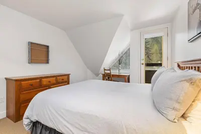 a white bedroom with a bed and a window at Foxglove by Whistler Premier in Whistler