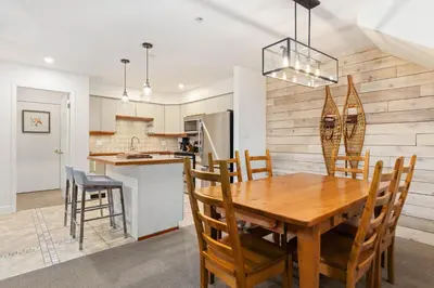 a kitchen and dining room with a wooden table and chairs at Foxglove by Whistler Premier in Whistler