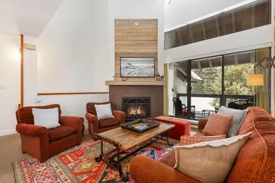 a living room with chairs and a fireplace at Foxglove by Whistler Premier in Whistler