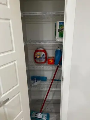 an open door of a refrigerator with a mop at The Oasis-A New 1 bed suite in Livingston Calgary close to the Airport in Calgary