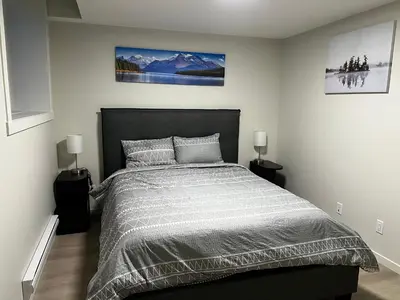 a bedroom with a large bed with two lamps at The Oasis-A New 1 bed suite in Livingston Calgary close to the Airport in Calgary