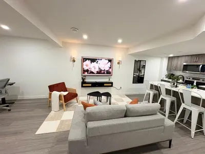 a living room with a couch and a kitchen at Coziest & Modern Basement Retreat East of Calgary in Chestermere