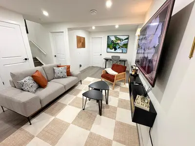 a living room with a couch and a tv at Coziest & Modern Basement Retreat East of Calgary in Chestermere