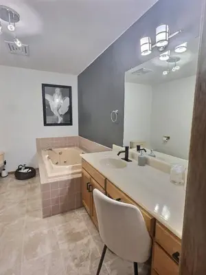a bathroom with a sink and a tub and a mirror at Vineyard Home Casa De Herrera in Keremeos