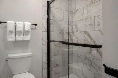 a bathroom with a shower with a toilet at Canalta Cochrane in Cochrane