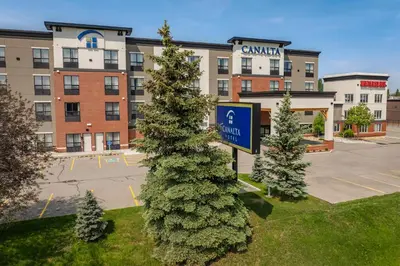 a sign in front of a building with a parking lot at Canalta Cochrane in Cochrane