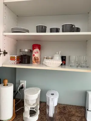 a kitchen shelf with cups and other items on it at 2 bedroom Suite with private entrance in Langley