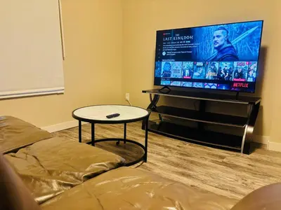 a living room with a couch and a flat screen tv at Main Floor 1 Bedroom Suite with Parking in Calgary