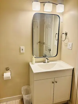 a bathroom with a sink and a large mirror at Main Floor 1 Bedroom Suite with Parking in Calgary