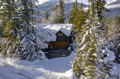 a cabin in the snow with snow covered trees at Hapala Chalet in Whistler