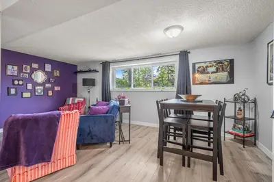 a living room with a blue couch and a table at Modern 3 Bedroom Suite Near Downtown & Stampede Grounds in Calgary