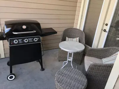 a grill on a porch with two chairs and a stool at Mountain View Retreat in Radium Hot Springs