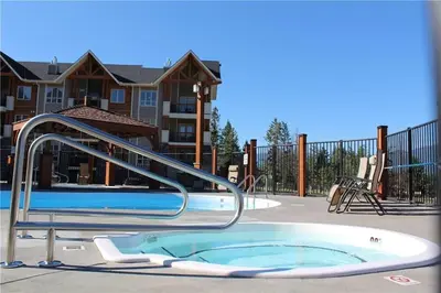 a swimming pool with a hot tub and a slide at Mountain View Retreat in Radium Hot Springs