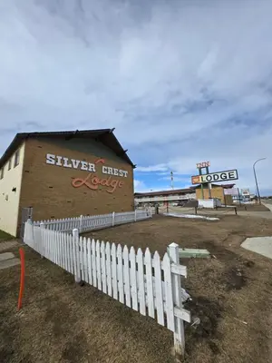 a building with a white fence in front of it at Silver crest lodge in Grande Prairie