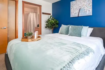 a large white bed in a room with a blue wall at Rocky Mountain Oasis-Mountain View! in Canmore
