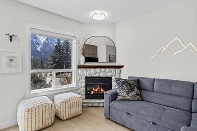 a living room with a couch and a fireplace at 2BR 2BA Harvie Heights Townhouse retreat with views in Canmore