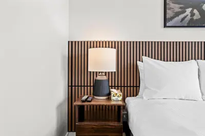 a bed with a nightstand with a lamp and a phone at 2BR 2BA Harvie Heights Townhouse retreat with views in Canmore